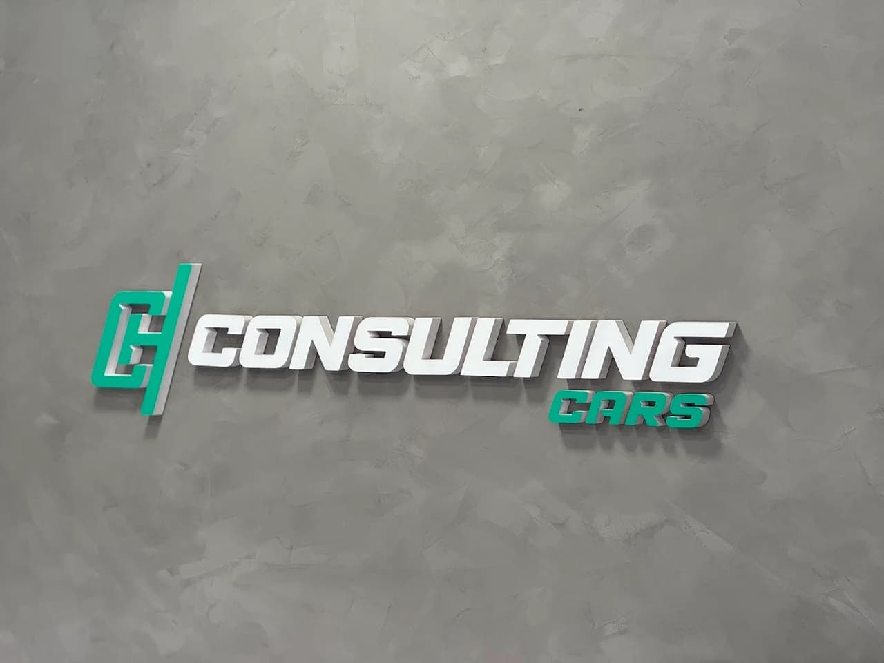 Letreiro da HConsulting Cars na parede de microcimento da loja