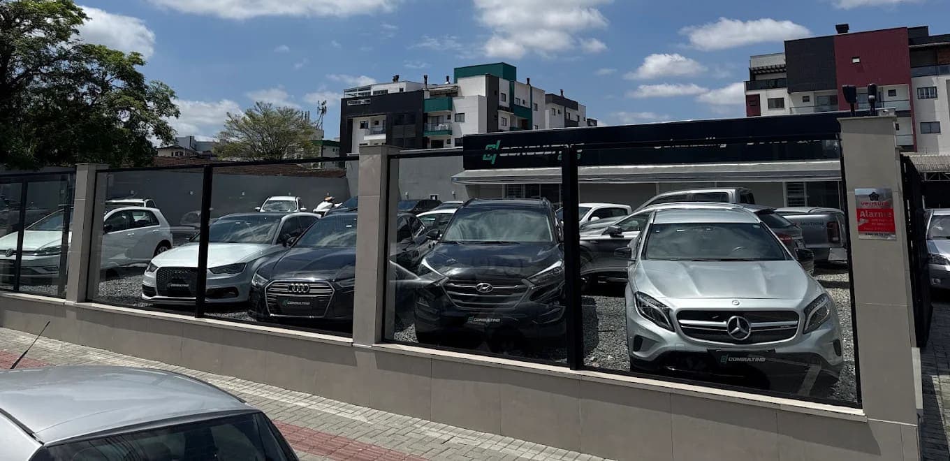 Fachada da HConsulting Cars na Rua Piratuba, com carros do estoque atrás do vidro
